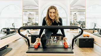 X-treme Pilates-Trainerin Olga trainiert auf dem Reformer.